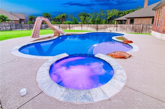 view of swimming pool featuring a water slide, a pool with connected hot tub, and a patio