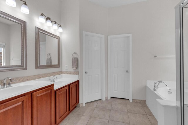 full bathroom with tile patterned flooring, a bath, and double vanity