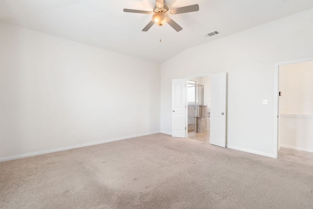 unfurnished bedroom featuring vaulted ceiling, light colored carpet, baseboards, ensuite bath, and ceiling fan