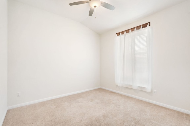spare room with light carpet, lofted ceiling, ceiling fan, and baseboards