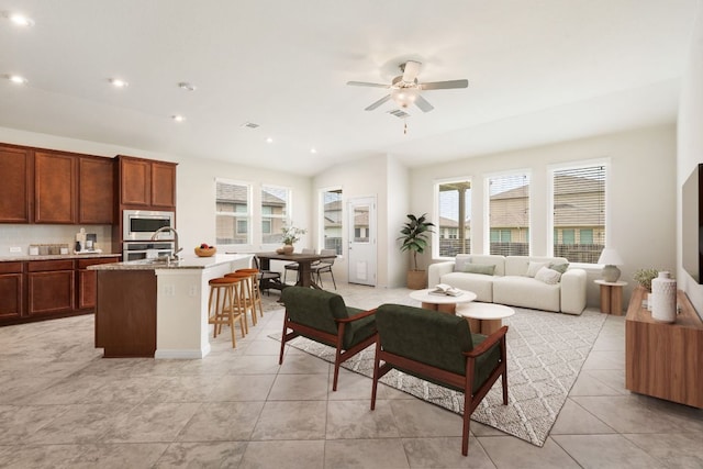 living room with a ceiling fan, light tile patterned flooring, and recessed lighting
