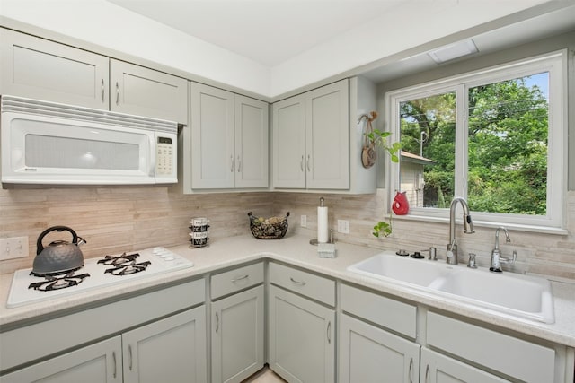 3000 Greenlawn Pkwy, Austin, TX 78757 - kitchen featuring white appliances, a sink, backsplash, and light countertops