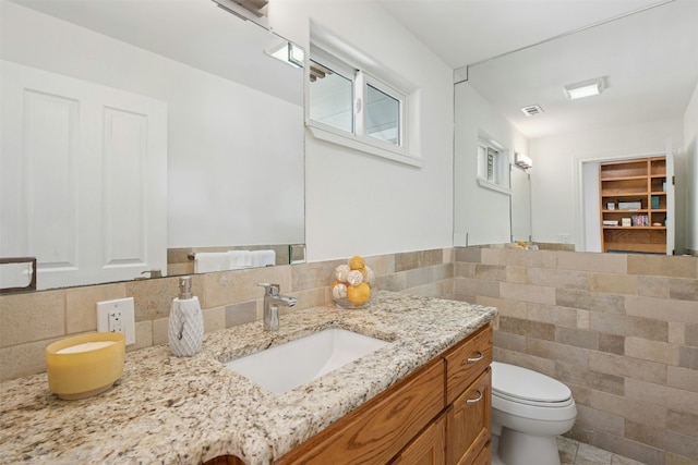 3000 Greenlawn Pkwy, Austin, TX 78757 - bathroom featuring toilet, vanity, and tile walls