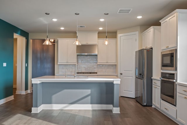 159 Nodena Dr, Dripping Springs, TX 78620 - kitchen with stainless steel appliances, light countertops, dark wood-type flooring, backsplash, and white cabinetry