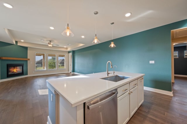 159 Nodena Dr, Dripping Springs, TX 78620 - kitchen featuring stainless steel dishwasher, a sink, white cabinets, a glass covered fireplace, and dark wood-style floors