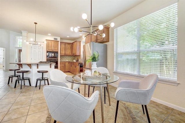 dining room with a chandelier, healthy amount of natural light, and light tile patterned floors