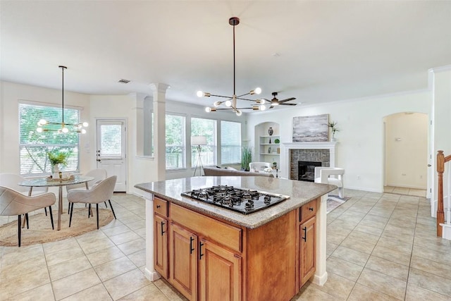 kitchen with a chandelier, black gas cooktop, light tile patterned floors, and a fireplace