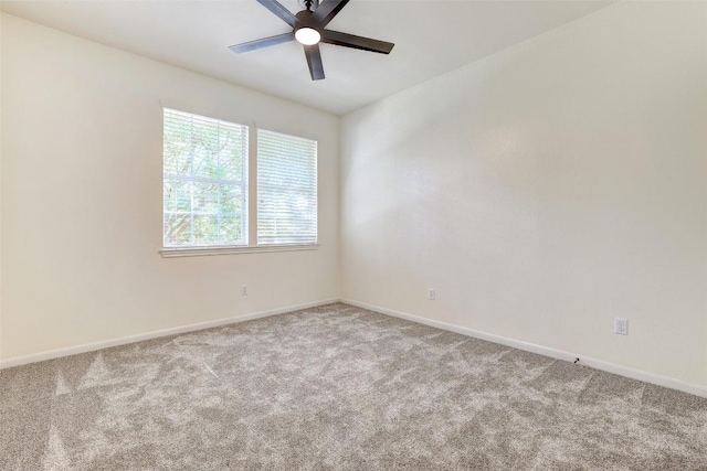 carpeted empty room with ceiling fan and baseboards