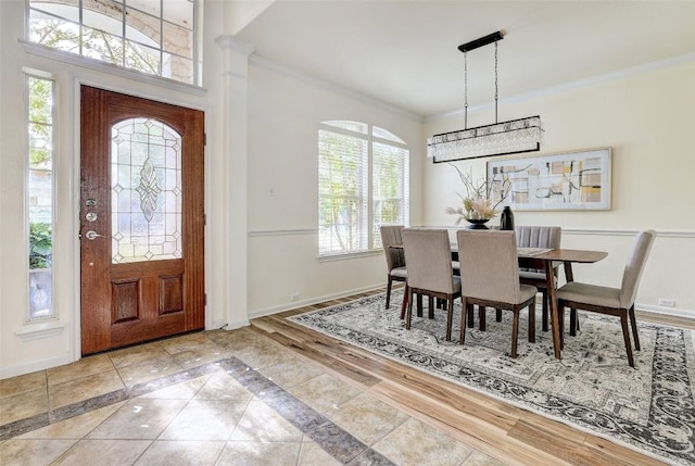 foyer with ornamental molding, plenty of natural light, baseboards, and inlaid floor details