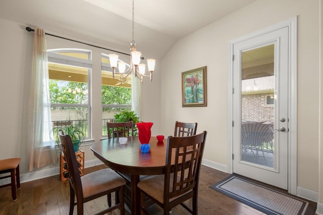 dining area with dark wood-style flooring, lofted ceiling, a chandelier, and baseboards