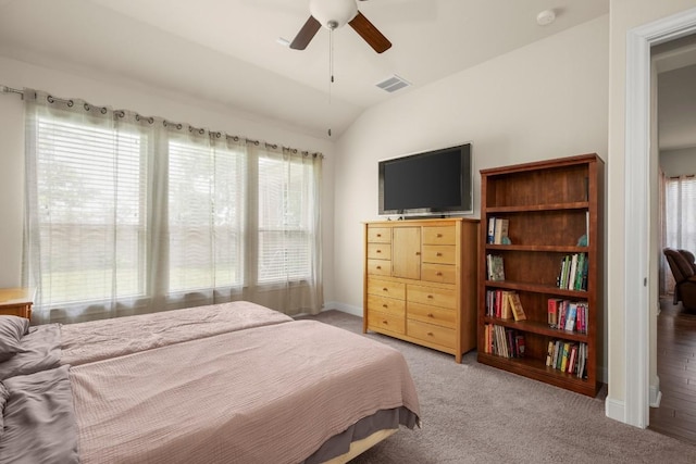 bedroom featuring light carpet, vaulted ceiling, baseboards, and a ceiling fan