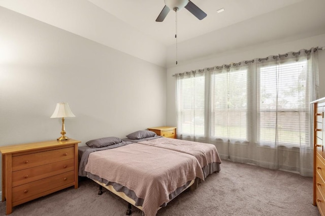 bedroom featuring multiple windows, light carpet, vaulted ceiling, and a ceiling fan