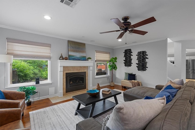 living room featuring a ceiling fan, crown molding, baseboards, recessed lighting, and wood finished floors