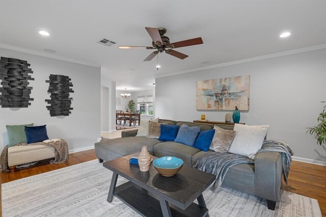 living area featuring a ceiling fan, light wood-style floors, recessed lighting, ornamental molding, and baseboards