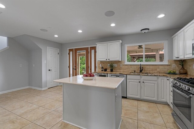 kitchen with appliances with stainless steel finishes, a sink, tasteful backsplash, light tile patterned floors, and recessed lighting