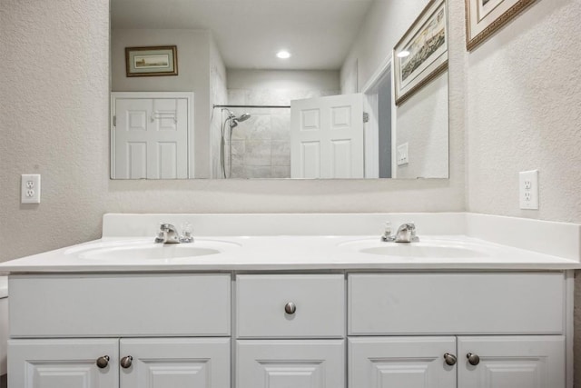 1413 Coffee Tree Dr, New Braunfels, TX 78130 - full bathroom with a textured wall, double vanity, and tiled shower