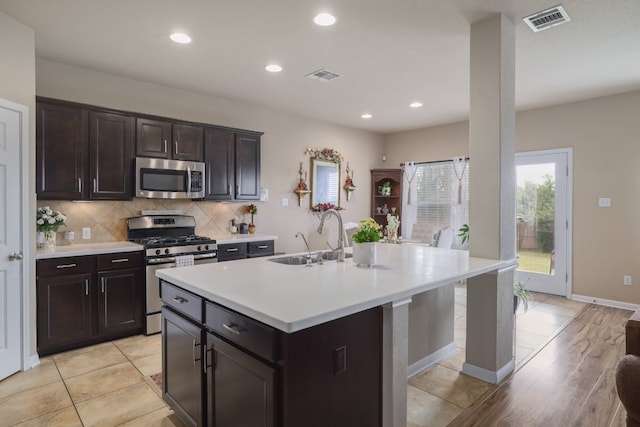 kitchen with stainless steel appliances, a sink, light countertops, backsplash, and recessed lighting