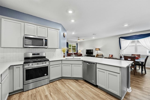 144 Shawii Pass, Leander, TX 78641 - kitchen featuring stainless steel appliances, a sink, a peninsula, tasteful backsplash, and recessed lighting
