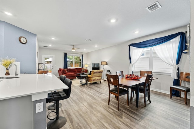 dining area with light wood-style floors, a ceiling fan, recessed lighting, and baseboards