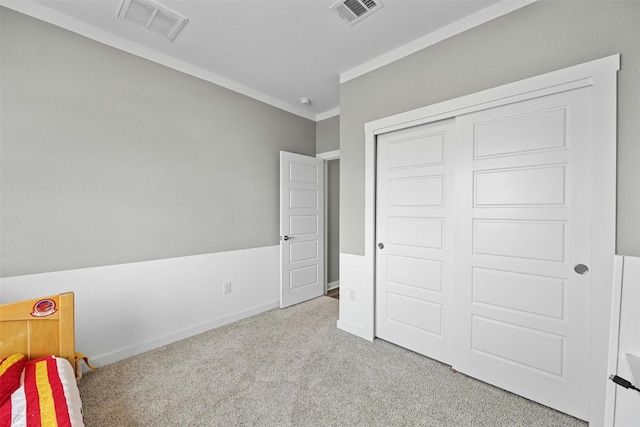 bedroom featuring carpet flooring, baseboards, ornamental molding, and a closet