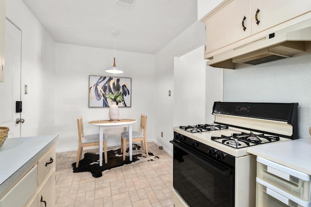 kitchen featuring range with gas stovetop, under cabinet range hood, light countertops, and baseboards