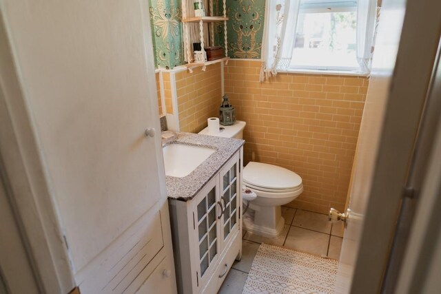 1305 Larkspur Rd, Austin, TX 78758 - half bathroom with tile walls, toilet, tile patterned floors, vanity, and wainscoting