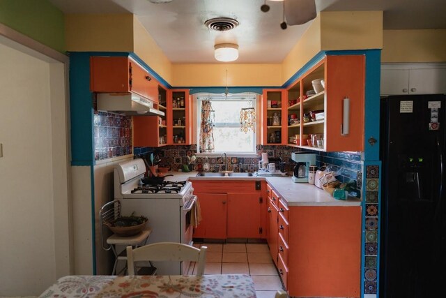 1305 Larkspur Rd, Austin, TX 78758 - kitchen featuring black refrigerator with ice dispenser, a sink, under cabinet range hood, white range with gas cooktop, and tasteful backsplash
