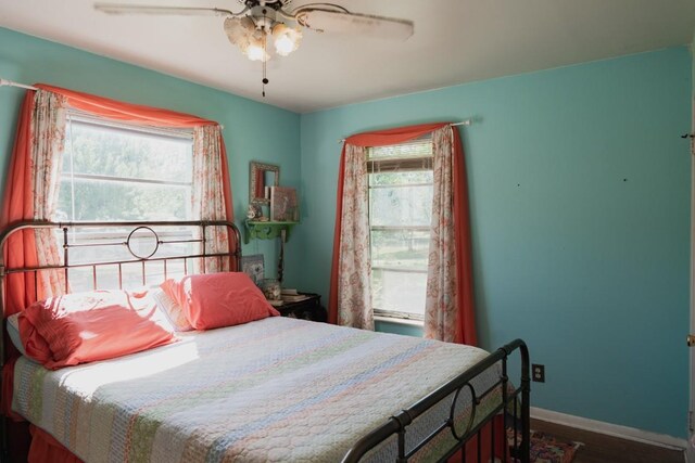 1305 Larkspur Rd, Austin, TX 78758 - bedroom featuring multiple windows, baseboards, wood finished floors, and a ceiling fan
