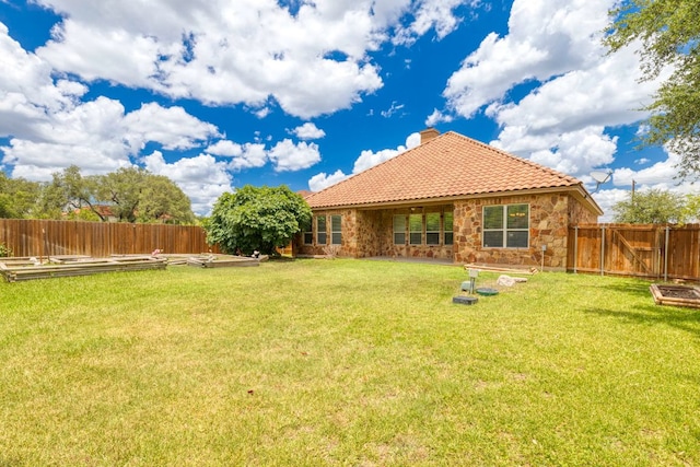 15105 General Williamson Dr, Austin, TX 78734 - rear view of property featuring a vegetable garden, a tile roof, stone siding, and a fenced backyard