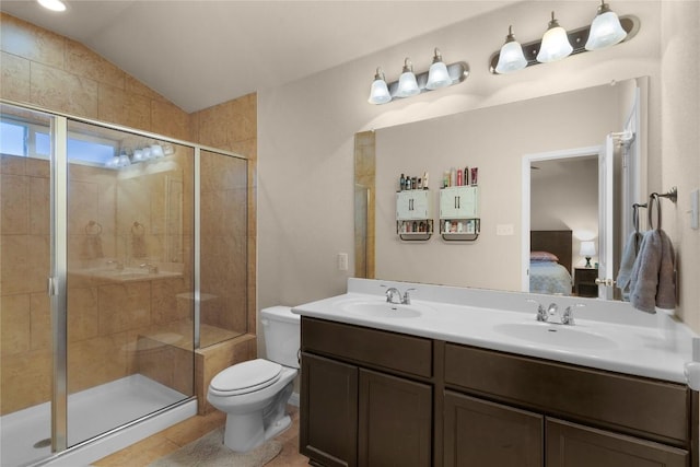 ensuite bathroom featuring a stall shower, toilet, lofted ceiling, double vanity, and tile patterned flooring