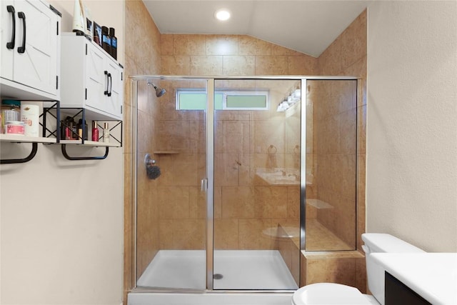 bathroom with a stall shower, toilet, lofted ceiling, and vanity