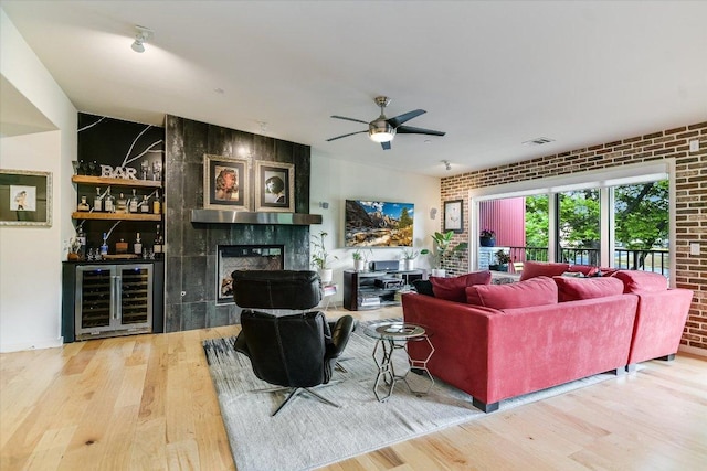 3200 Grandview St Unit 15, Austin, TX 78705 - living room featuring wine cooler, wood finished floors, a bar, a ceiling fan, and brick wall