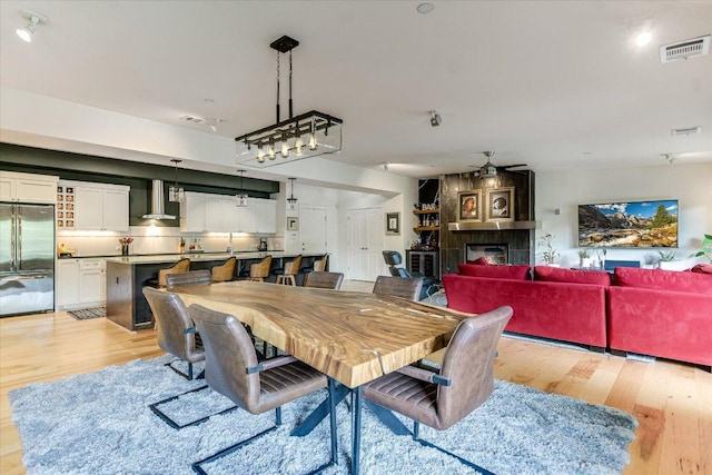 3200 Grandview St Unit 15, Austin, TX 78705 - dining area featuring light wood-style floors, ceiling fan, and a fireplace