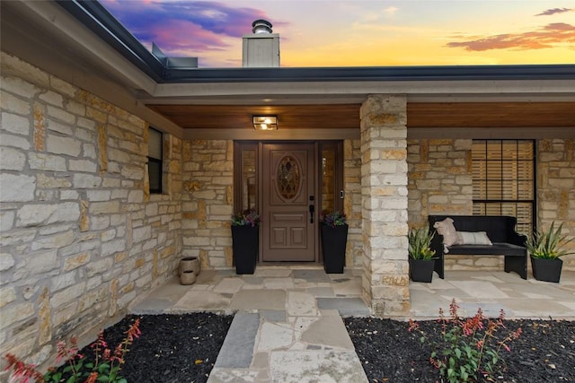 701 W Esparada Dr, Georgetown, TX 78628 - exterior entry at dusk featuring stone siding and a porch