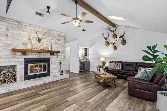701 W Esparada Dr, Georgetown, TX 78628 - living area featuring beverage cooler, a stone fireplace, ceiling fan, and wood finished floors
