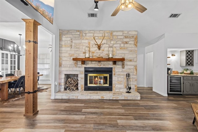 701 W Esparada Dr, Georgetown, TX 78628 - living area featuring beverage cooler, ceiling fan, a bar, wood finished floors, and a fireplace