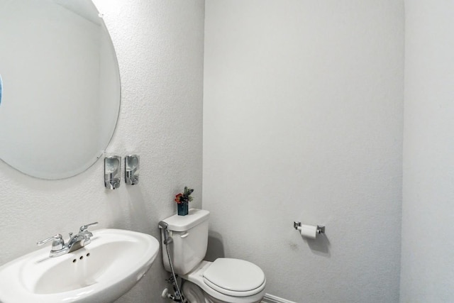 12003 Corsicana Trl, Manor, TX 78653 - bathroom featuring a sink, toilet, and a textured wall