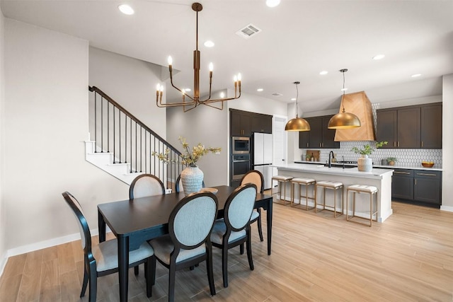 324 Pisa Ln, Georgetown, TX 78628 - dining area featuring a chandelier, light wood-style floors, recessed lighting, stairs, and baseboards