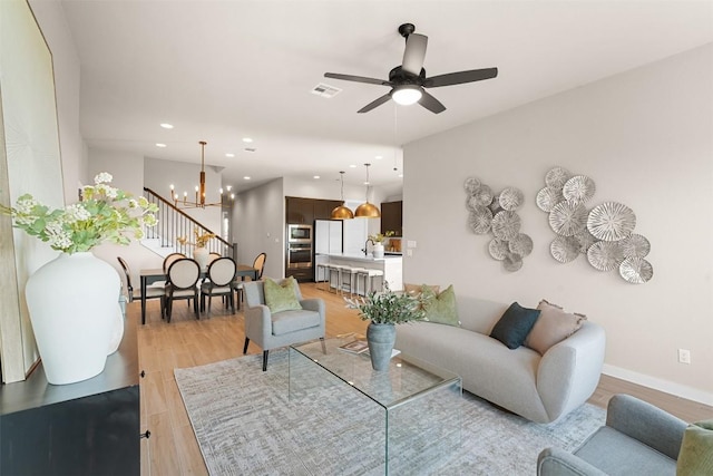324 Pisa Ln, Georgetown, TX 78628 - living room featuring a chandelier, recessed lighting, light wood-style floors, ceiling fan, and baseboards