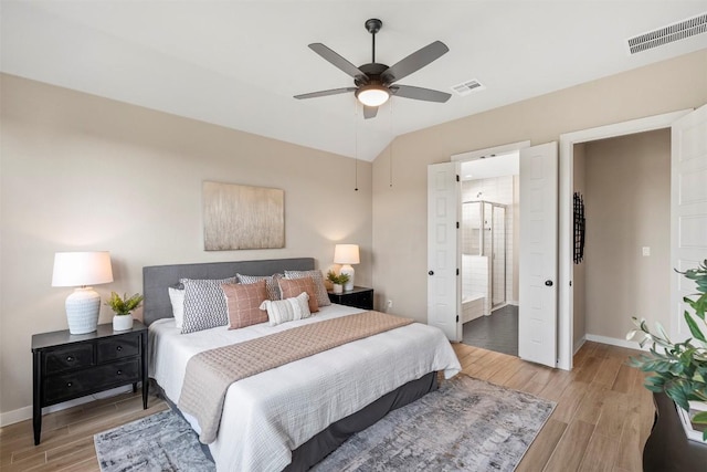 324 Pisa Ln, Georgetown, TX 78628 - bedroom featuring light wood finished floors, baseboards, lofted ceiling, ceiling fan, and ensuite bathroom