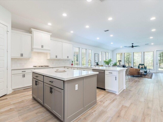 205 William Clayton Dr, Buda, TX 78610 - kitchen with dishwasher, gray cabinets, a peninsula, a center island, and light countertops