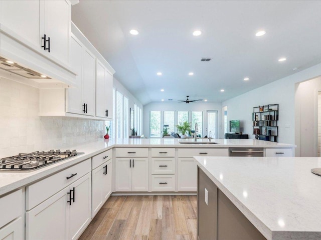 kitchen with stainless steel appliances, a sink, light wood-style flooring, recessed lighting, and a peninsula