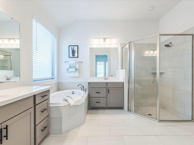 full bathroom with healthy amount of natural light, a stall shower, a bath, tile patterned flooring, and vaulted ceiling