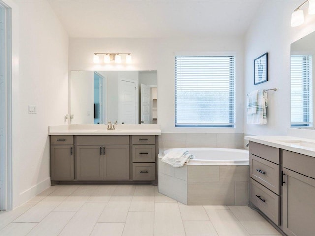 full bathroom with healthy amount of natural light, a garden tub, and two vanities
