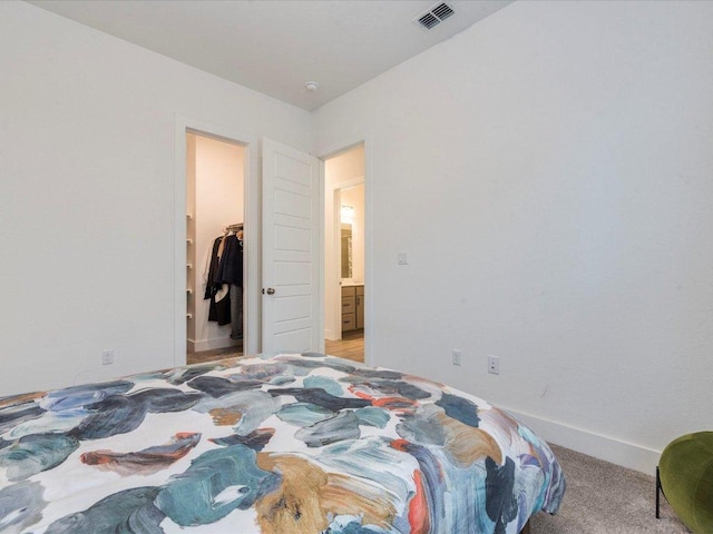 bedroom featuring a spacious closet and baseboards