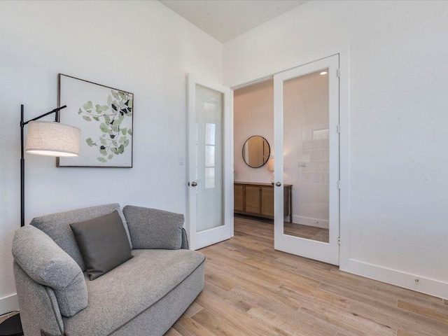 living area with french doors, light wood finished floors, and baseboards