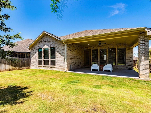 back of property with a patio, ceiling fan, brick siding, and roof with shingles