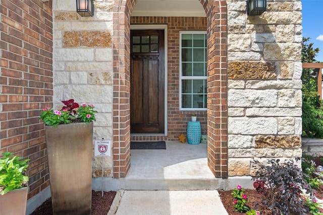 entrance to property featuring brick siding
