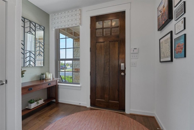 foyer entrance with wood finished floors and baseboards