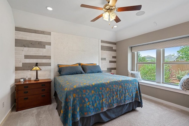 bedroom featuring baseboards, light carpet, recessed lighting, wooden walls, and ceiling fan